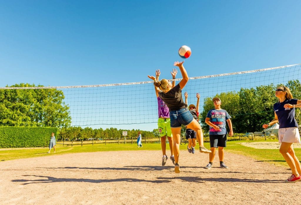 Vacanciers jouant au beach-volley au camping en Normandie